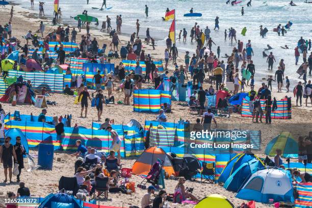 Holidaymakers enjoying themselves on Fistral Beach in Newquay in Cornwall.