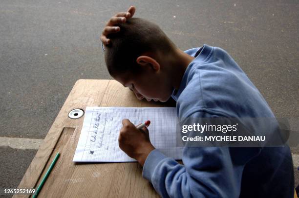 Un élève de CM2 écrit une dictée le 08 juin 2007 sous le préau de l'école primaire du Puits Picard, à Caen.