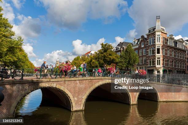 Cyclists cross a bridge over the Keizersgracht canal in Amsterdam.