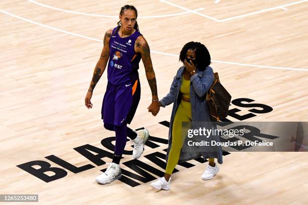 Brittney Griner of the Phoenix Mercury walks hand and hand with wife Cherelle Watson after defeating the Dallas Wings at Feld Entertainment Center on...