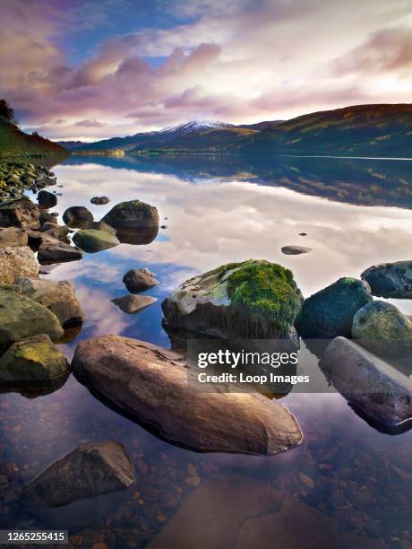 View across the calm surface of Loch Rannoch as the sun sets.