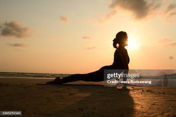 silhouette yoga poses urdhva mukha svanasana - woman stretching sunset stock-fotos und bilder