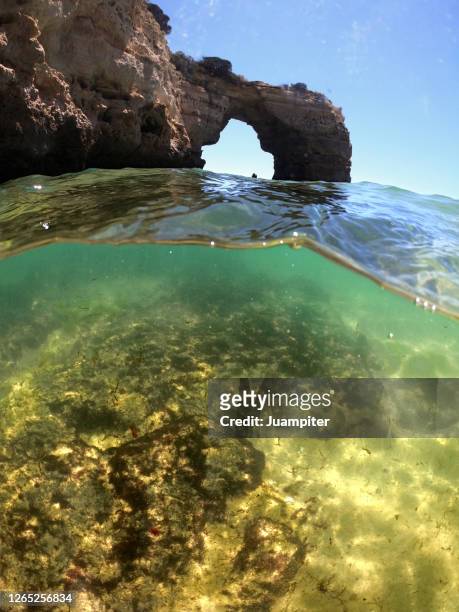 arco de praia albandeira encima y debajo del agua - debajo del agua foto e immagini stock