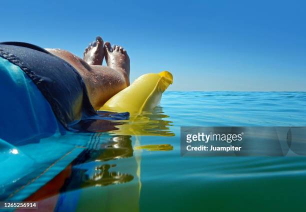 vista lateral de un hombre en una colchoneta disfrutando del mar en verano - vista lateral 個照片及圖片檔