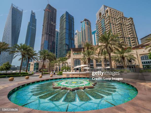Richly coloured fountain of Arabic tile beneath the opulent residential towers of the Dubai Marina.