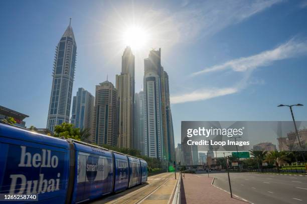 The words hello Dubai rush past with the tram leading toward the Dubai Marina.