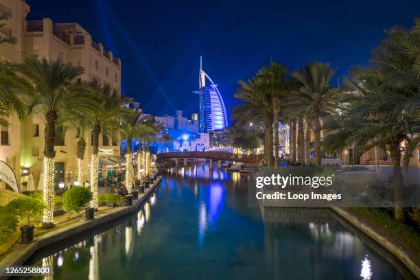 The Burj al Arab is illuminated in beams of light in Souk Madinat Jumeirah.