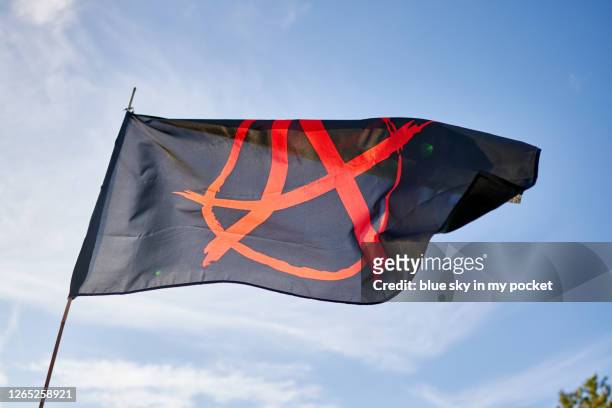 an anarchy flag blowing in the wind - símbolo da anarquia imagens e fotografias de stock