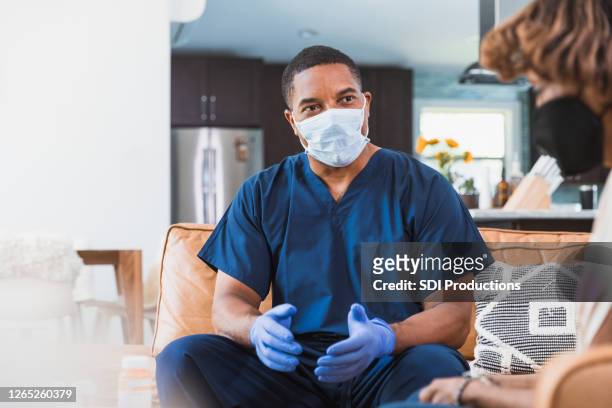 home healthcare nurse visits with patient during   covid-19 - black glove stock pictures, royalty-free photos & images