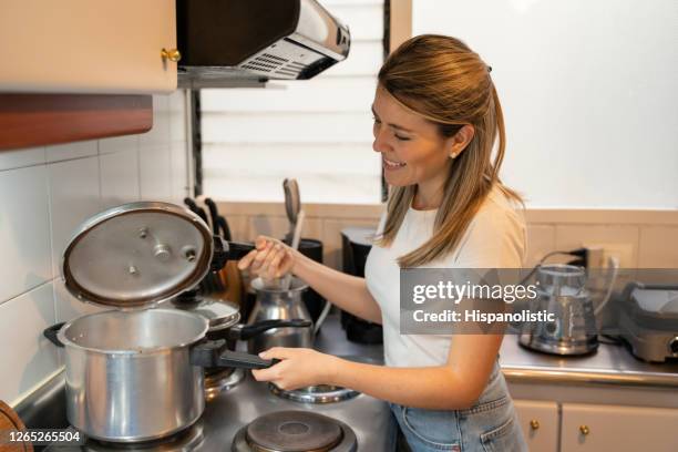 mujer cocinando en casa usando una olla a presión - olla a presión fotografías e imágenes de stock