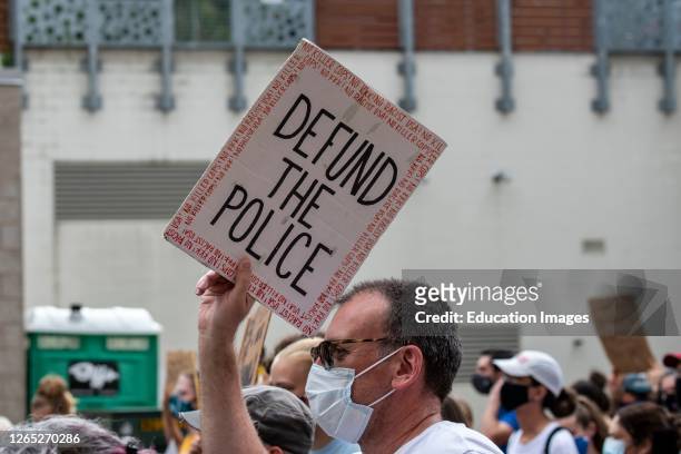 St. Paul, Minnesota, No police in our schools protest, Protester marching with defund the police sign.