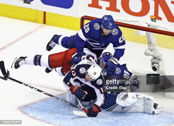 Blake Coleman and Andrei Vasilevskiy of the Tampa Bay Lightning defend against Cam Atkinson of the Columbus Blue Jackets during the first period in...
