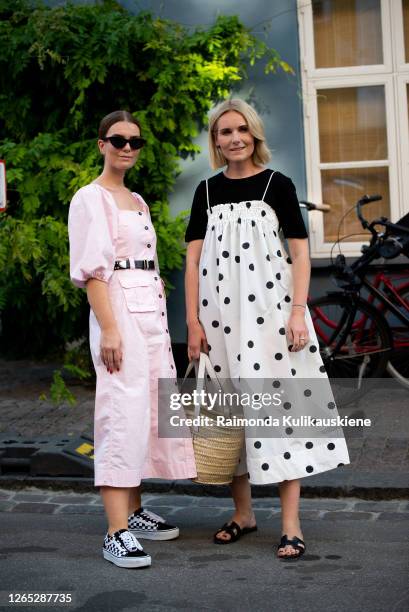 Guests outside Ganni wearing pink denim dress and black shirt with white polka dots dress during Copenhagen fashion week SS21 on August 10, 2020 in...