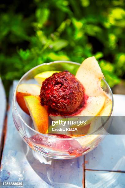 Mulberries icecream homemade on top of peaches. Fruit salad. Sicilian Summer in a garden. Italy. Europe.