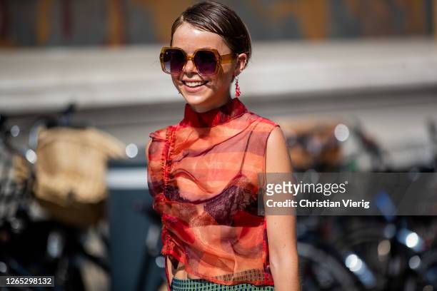 Guest is seen wearing sheer top, sunglasses outside Remain Birger Christensen during Copenhagen Fashion Week Spring/Summer 2021 on August 11, 2020 in...