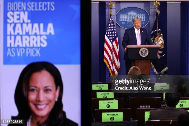 President Donald Trump speaks as a picture of Sen. Kamala Harris is seen on a screen during a news conference in the James Brady Press Briefing Room...