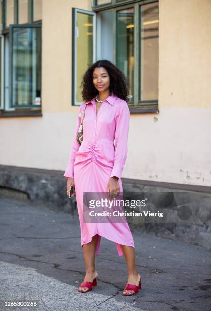 Guest wearing pink dress, red sandals is seen outside Samsøe & Samsøe during Copenhagen Fashion Week Spring/Summer 2021 on August 11, 2020 in...