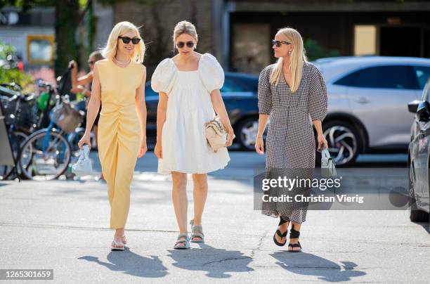 Guests wearing yellow dress, white dress, checked dress are seen outside Samsøe & Samsøe during Copenhagen Fashion Week Spring/Summer 2021 on August...
