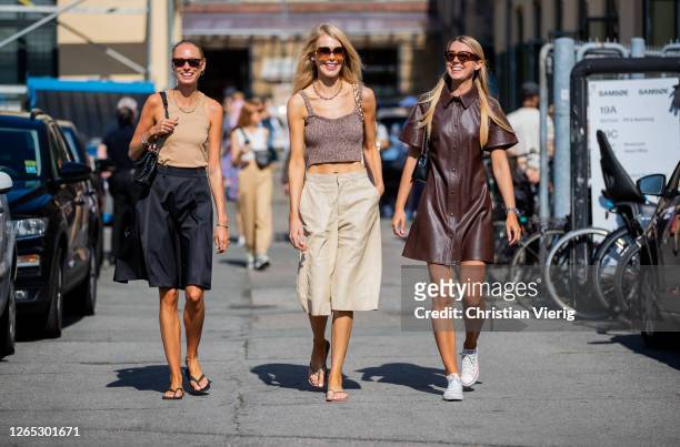 Guests wearing brown dress, shorts, cropped top, sunglasses are seen outside Samsøe & Samsøe during Copenhagen Fashion Week Spring/Summer 2021 on...