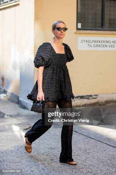 Cecilie Thorsmark wearing black trousers, black dress, black bag is seen outside Samsøe & Samsøe during Copenhagen Fashion Week Spring/Summer 2021 on...