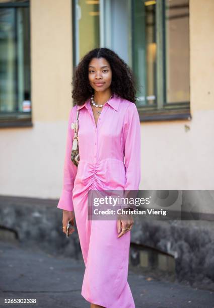 Guest wearing pink dress is seen outside Samsøe & Samsøe during Copenhagen Fashion Week Spring/Summer 2021 on August 11, 2020 in Copenhagen, Denmark.