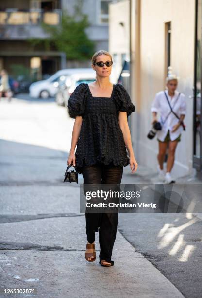 Cecilie Thorsmark wearing black trousers, black dress, black bag is seen outside Samsøe & Samsøe during Copenhagen Fashion Week Spring/Summer 2021 on...