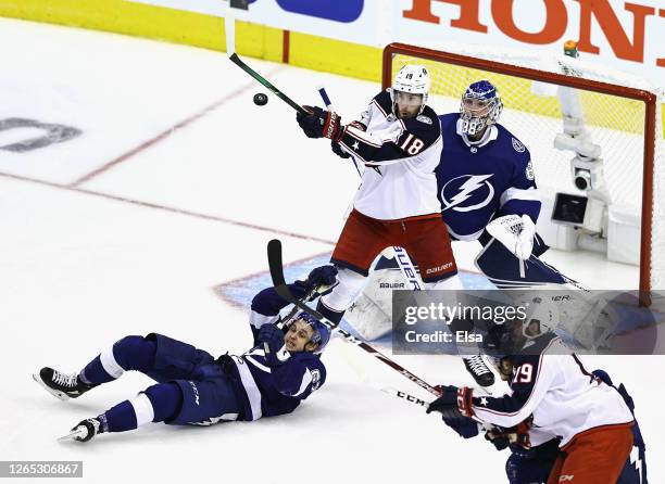 Pierre-Luc Dubois of the Columbus Blue Jackets bats the puck as Mitchell Stephens and Andrei Vasilevskiy of the Tampa Bay Lightning defend the net...