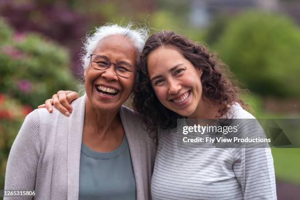 gemischte rasse mutter und tochter gehen und sprechen zusammen draußen - mother adult daughter stock-fotos und bilder