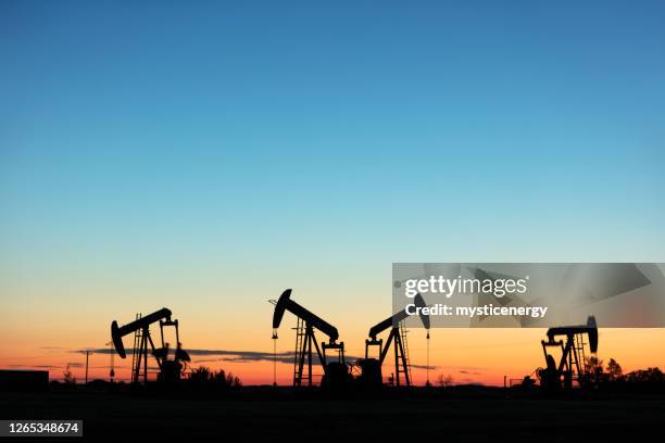 prairie oliepomp jacks canada usa - oil pump stockfoto's en -beelden