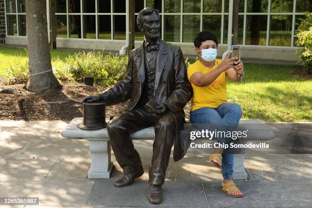 Nicolette Holness of Bismarck, North Dakota, takes a selfie with a statue of President Abraham Lincoln outside the visitor center at the Gettysburg...