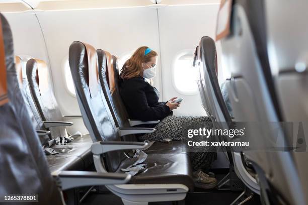 socially distanced portrait of teenage traveler in kn95 mask - airplane seats stock pictures, royalty-free photos & images