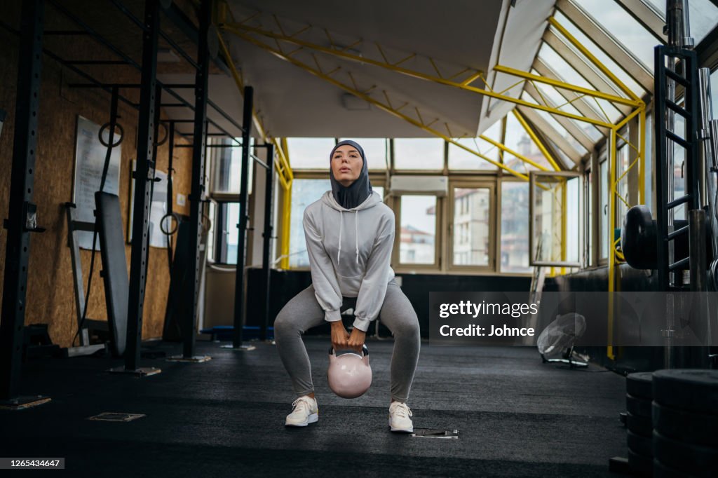 Mulher muçulmana se exercitando na academia