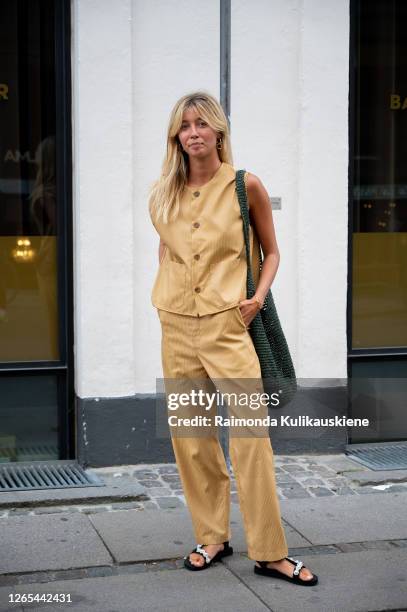 Guest outside Lovechild 1979 wearing beige pants and shirt with front buttons during Copenhagen fashion week SS21 on August 11, 2020 in Copenhagen,...