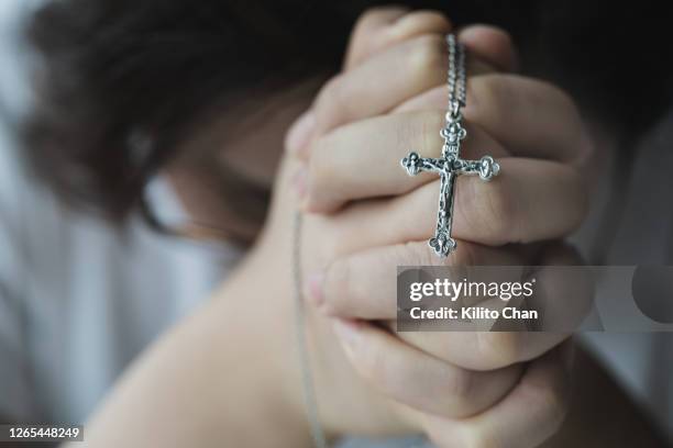 female hand holding rosary beads - hangers stockfoto's en -beelden