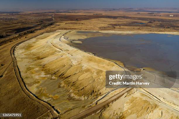 aerial view of environmentally dangerous toxic acid mine drainage running down the sides of a tailing dam at a mine - relave fotografías e imágenes de stock