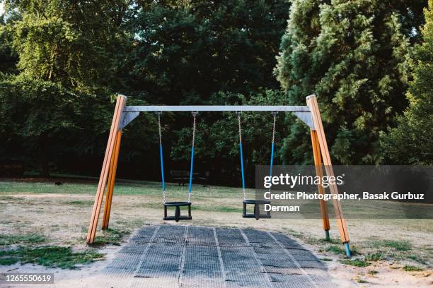 swings at children's playground - playground stock pictures, royalty-free photos & images