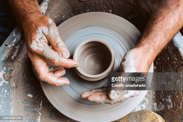 potter's hands working clay on a potter's wheel - craft stock-fotos und bilder