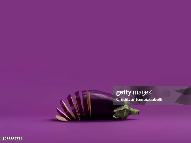 sliced aubergine on a purple background - melanzana foto e immagini stock