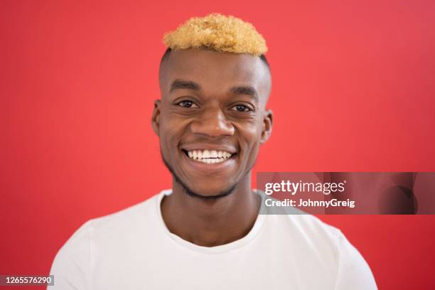 retrato de hombre negro casual de 25 años sonriendo a la cámara - corte de pelo con media cabeza rapada fotografías e imágenes de stock