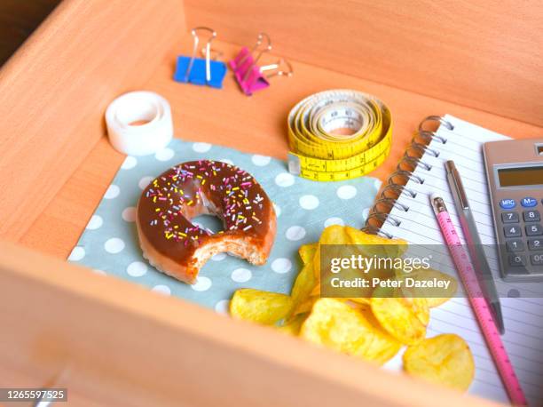 doughnut and potato chips in office desk - bulimia 個照片及圖片檔