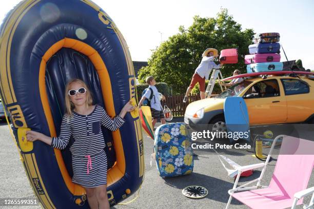 family loading up car to go on holiday - too small stockfoto's en -beelden