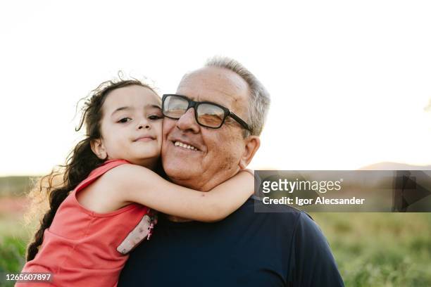 granddaughter hugged with grandpa outdoors - granddaughter stock pictures, royalty-free photos & images