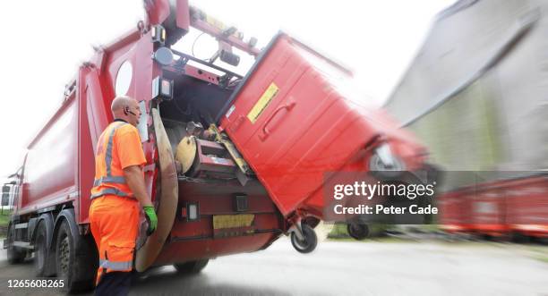 binman operating back of lorry - dustbin lorry stock pictures, royalty-free photos & images