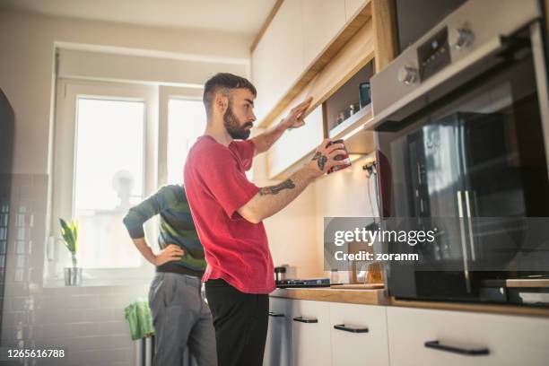 young man fetching nescafe can to make coffee for him and his boyfriend - tea can stock pictures, royalty-free photos & images