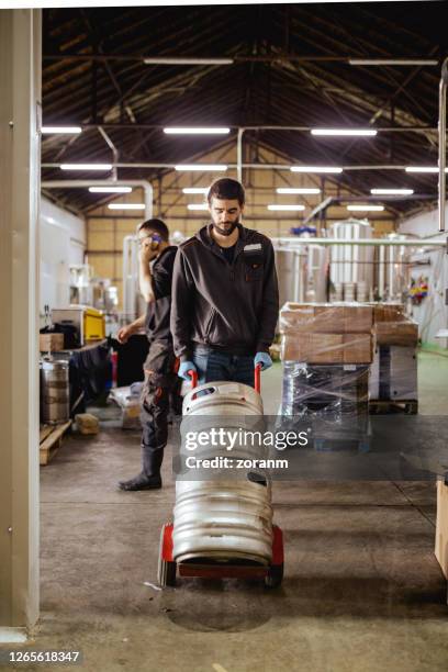 junge männer arbeiten im brauerei-distributionslager - beer cart stock-fotos und bilder