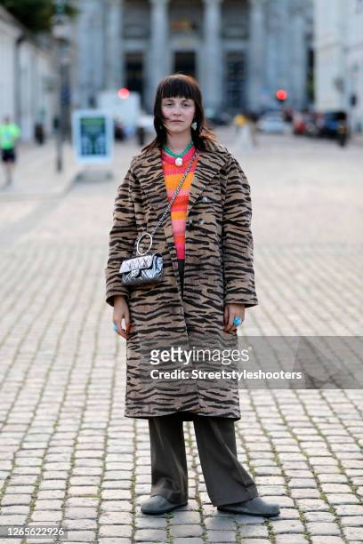Influencer and stylist Sissi Pohle, wearing a animal printed coat by Baum und Pferdegarten, a orange, red, yellow and rose striped sweater by Baum...
