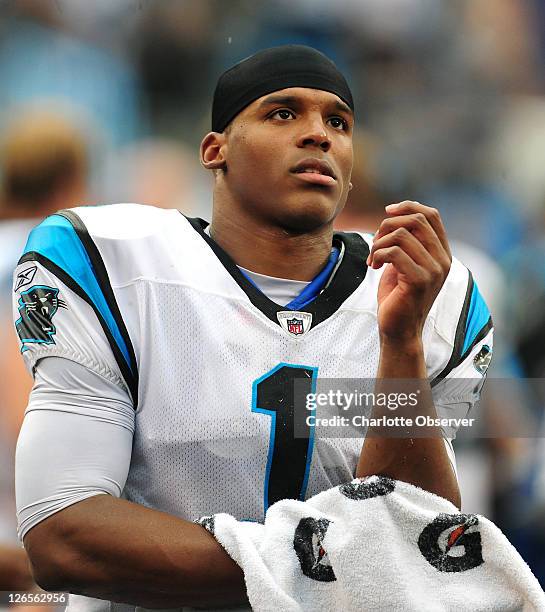 Carolina Panthers quarterback Cam Newton wipes the water and dirt from his arms following a series against the Jacksonville Jaguars in the fourth...