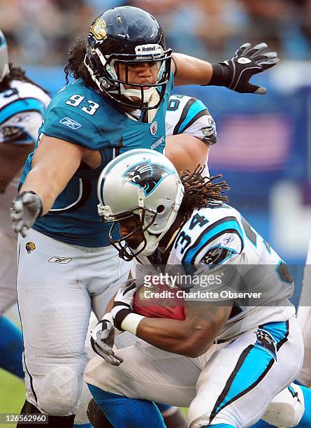 Carolina Panthers running back DeAngelo Williams tries to duck under the arms of Jacksonville Jaguars defensive tackle Tyson Alualu on a run during...