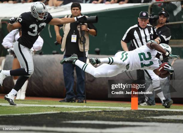 LaDainian Tomlinson of the New York Jets is pushed out of bounds at the one yard line by Tyvon Branch of the Oakland Raiders at O.co Coliseum on...