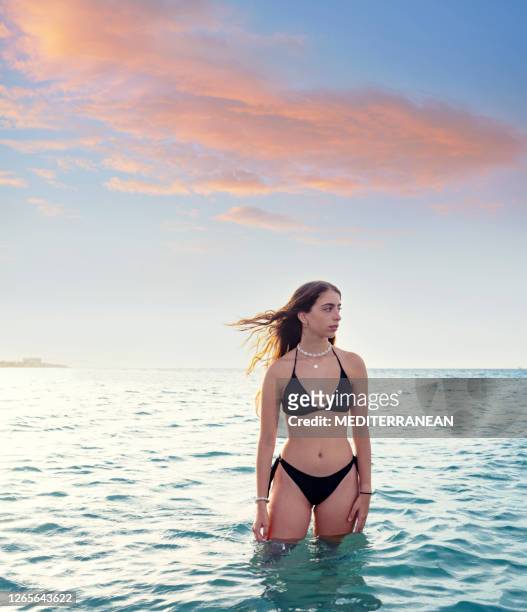 bikini brunette girl in the beach relaxed at sunset - swimsuit models girls stock pictures, royalty-free photos & images
